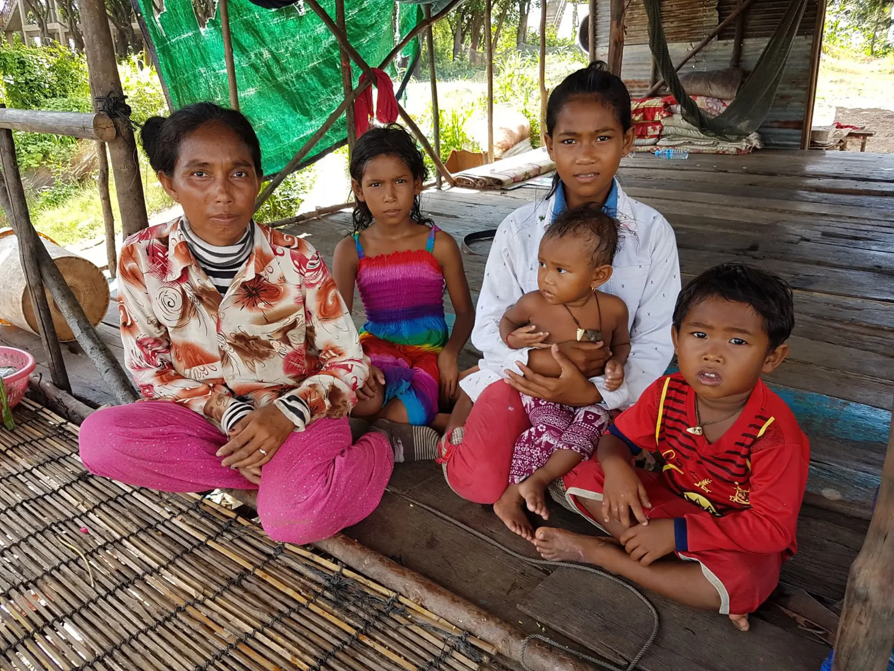 Une famille soutenue par l'association devant sa maison à Siem Reap